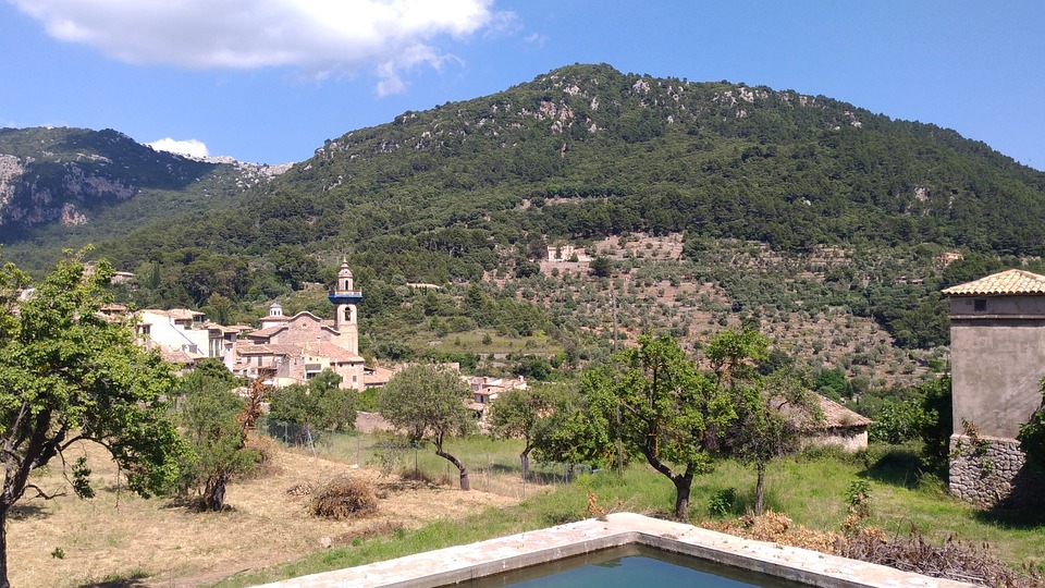 Valldemossa. De gekleurde huisjes zijn bedekt met exotische bloemen. Dit bergdorp, wat zich in een groenrijke omgeving bevindt, ligt bovendien in een vallei wat voor een mooi gezicht zorgt.